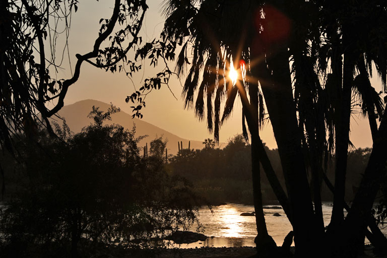 dunstiger sonnenaufgang ueber dem kunene, camp cornie, namibia