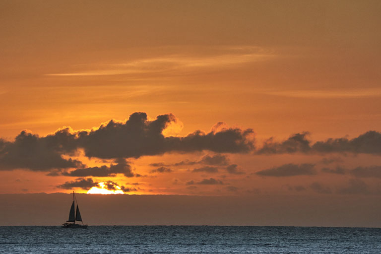 sonnenuntergang mit segelschiff am strand von la preneuse, mauritius im dezember 2022