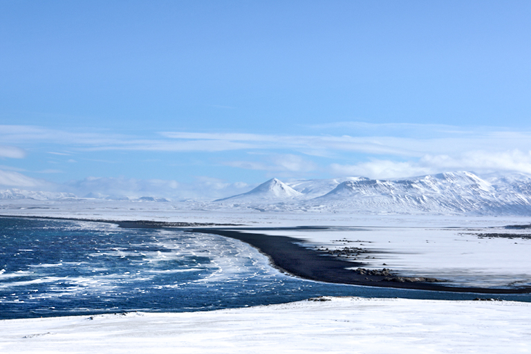 meer, lavastrand und verschneite berge am húnafjörður, island, märz 2024